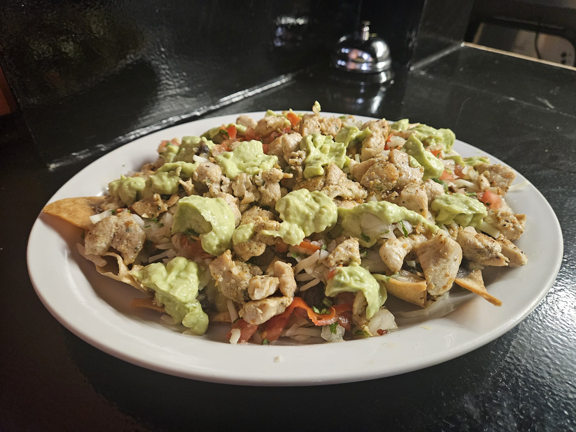 Nachos garnis avec viande au choix (bifteck, chorizo, poulet), des haricots, fromage et de la salade mexicaine.